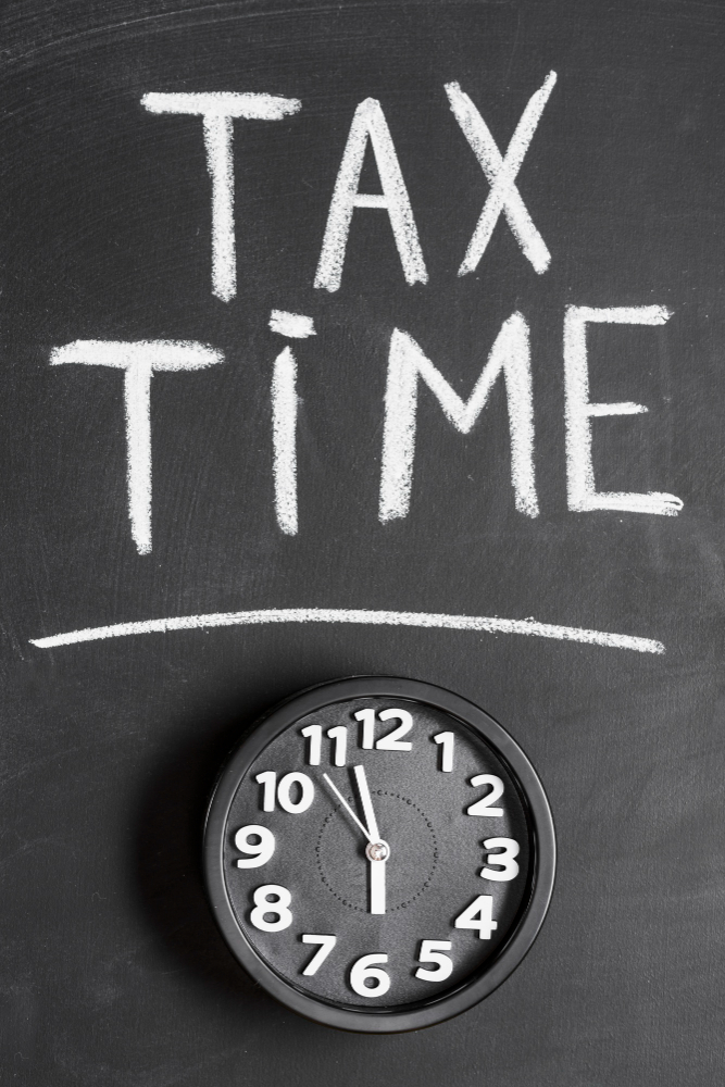 Tax time written in chalk above a black clock.